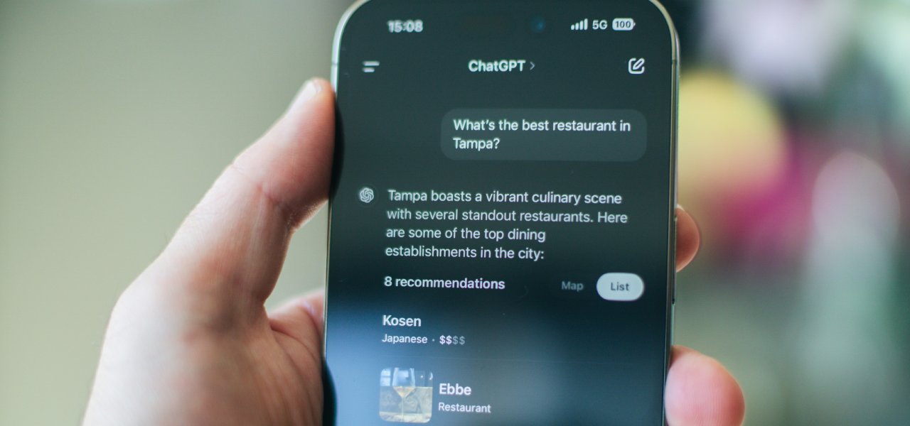 A hand holding a phone asking ChatGPT for restaurant recommendations