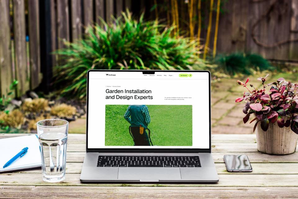 Laptop beside garden with landscaping website on screen