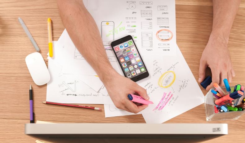 Person with papers on desk planning a website project