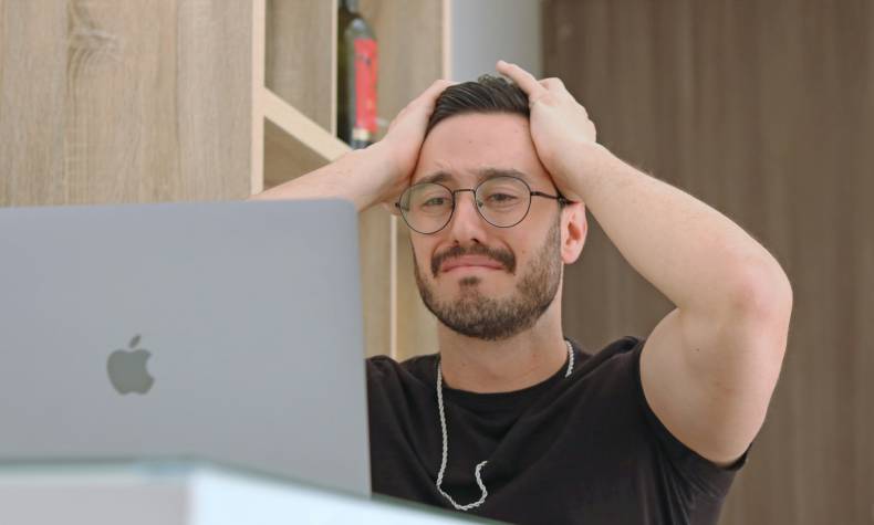 Frustrated man looking at laptop