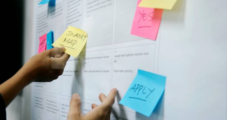 Wall board with post it notes containing ux tips