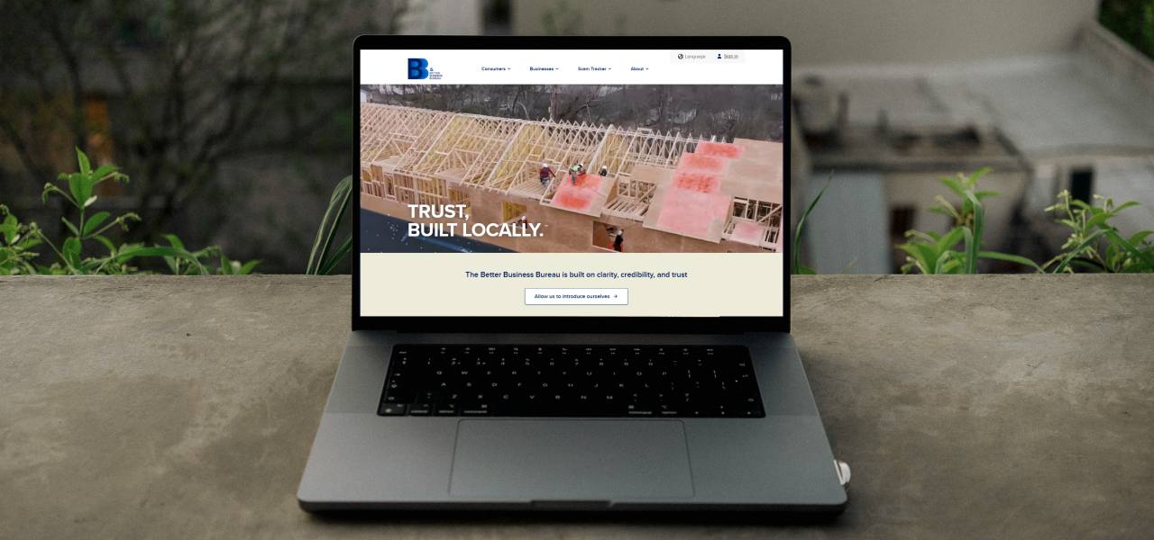 Laptop on an outdoor ledge showing Better Business Bureau website
