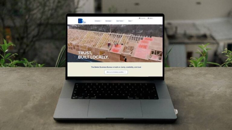 Laptop on an outdoor ledge showing Better Business Bureau website